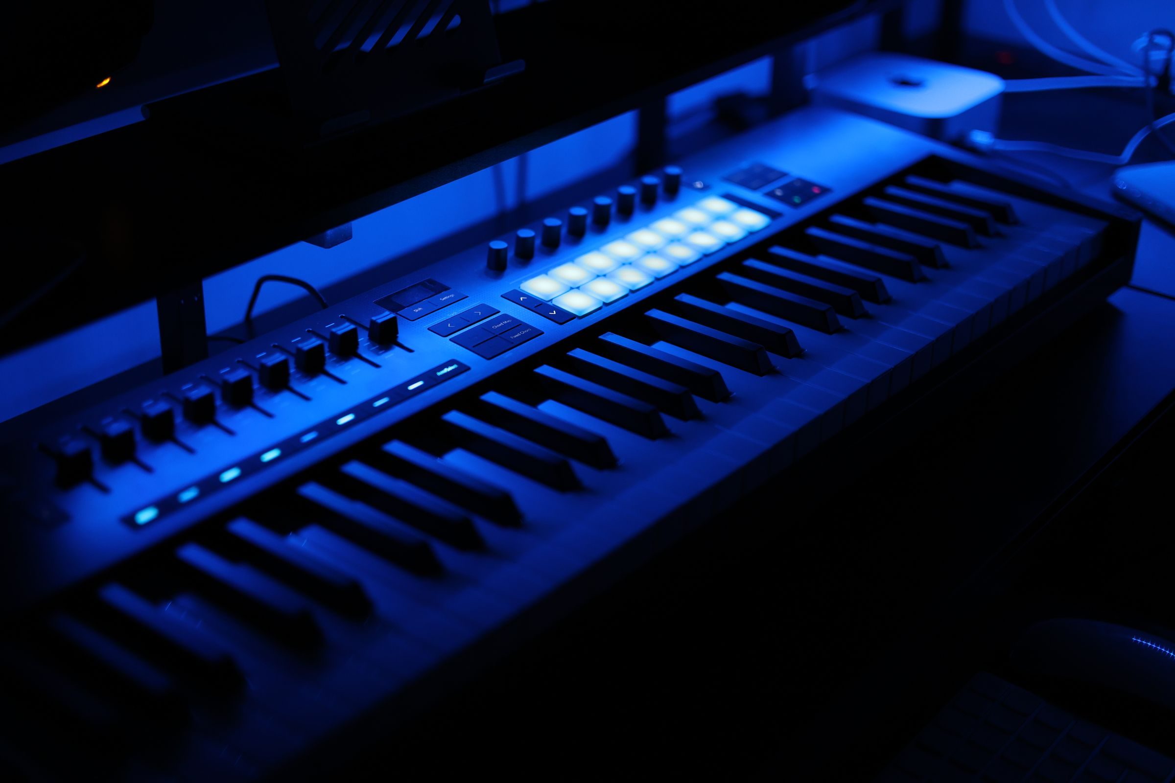 Clavier MIDI de vingt-cinq touches avec pads et molettes posé sur un bureau